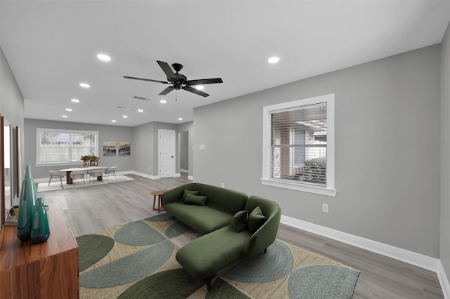 living area featuring visible vents, baseboards, wood finished floors, and recessed lighting