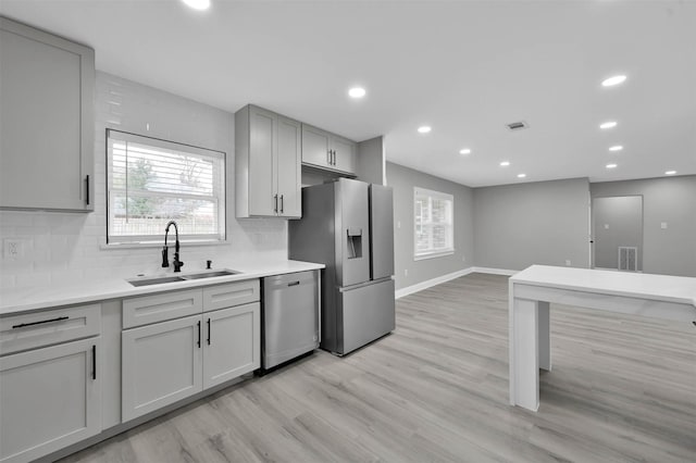 kitchen featuring appliances with stainless steel finishes, visible vents, a sink, and tasteful backsplash