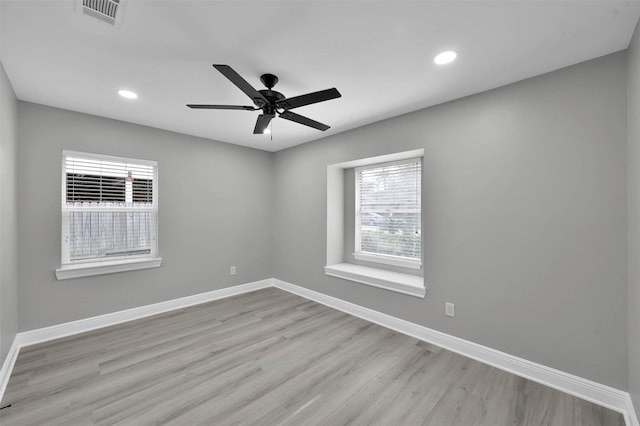 unfurnished room featuring recessed lighting, wood finished floors, visible vents, and baseboards