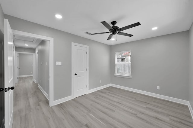 empty room featuring recessed lighting, visible vents, light wood-style floors, baseboards, and attic access