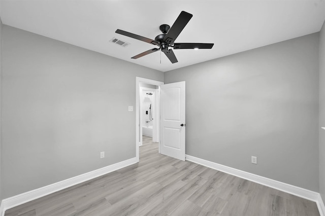 spare room with visible vents, a ceiling fan, light wood-style flooring, and baseboards