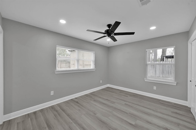 unfurnished room with a healthy amount of sunlight, baseboards, wood finished floors, and recessed lighting