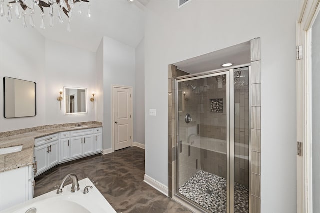 bathroom featuring double vanity, a stall shower, baseboards, a high ceiling, and a sink