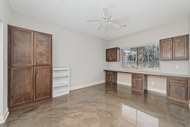 interior space featuring ceiling fan, built in desk, visible vents, and baseboards