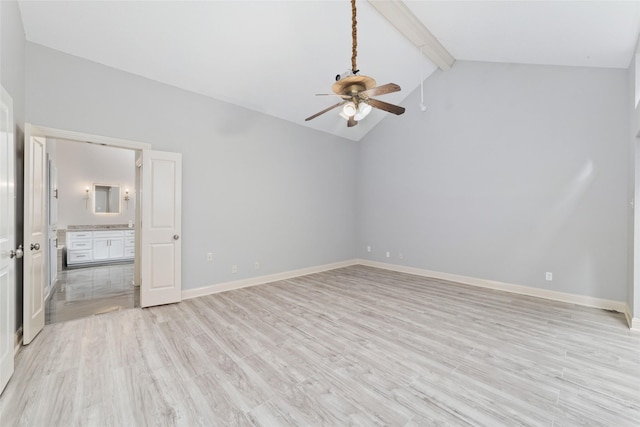 unfurnished bedroom featuring vaulted ceiling with beams, ceiling fan, ensuite bathroom, light wood-style flooring, and baseboards