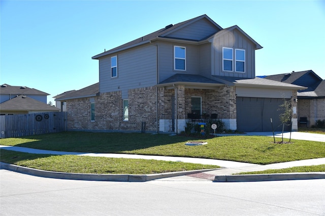 traditional home with concrete driveway, fence, a front lawn, board and batten siding, and brick siding