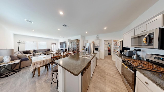 kitchen with visible vents, appliances with stainless steel finishes, white cabinets, and light wood-style flooring