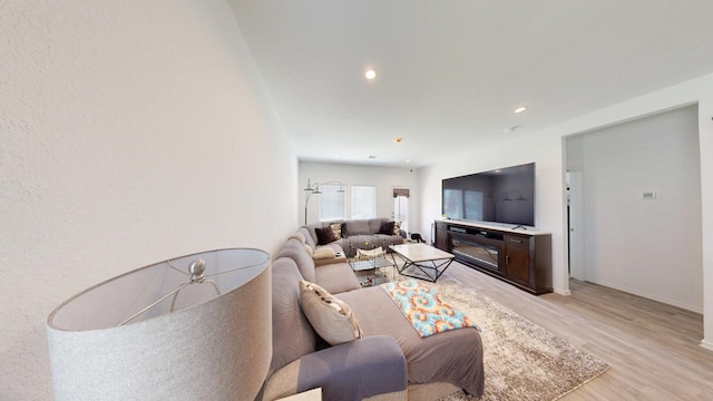 living room with baseboards, recessed lighting, and light wood-style floors