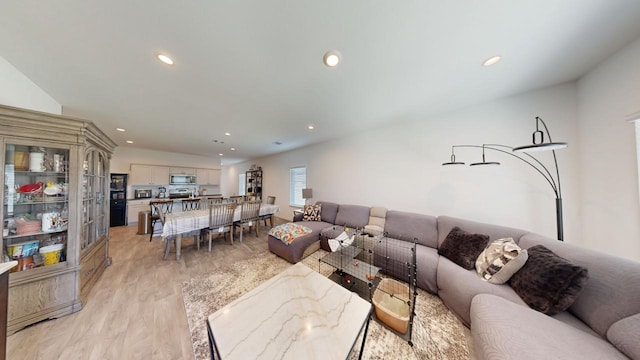 living area with light wood finished floors and recessed lighting