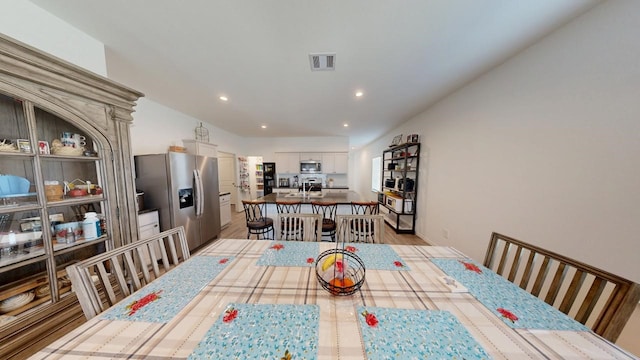 dining space with light wood-style flooring, visible vents, and recessed lighting