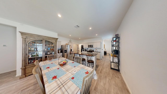 dining space with light wood-type flooring, baseboards, visible vents, and recessed lighting