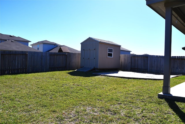 view of yard featuring an outbuilding, a patio area, a fenced backyard, and a storage unit