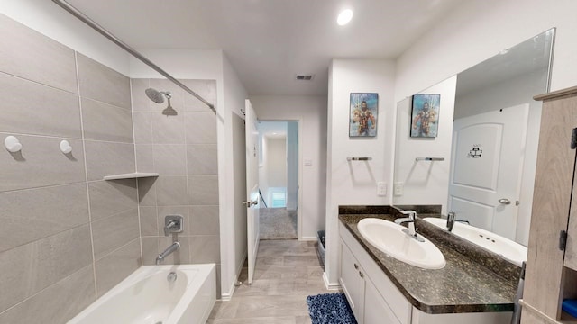 bathroom featuring visible vents, shower / washtub combination, vanity, and baseboards