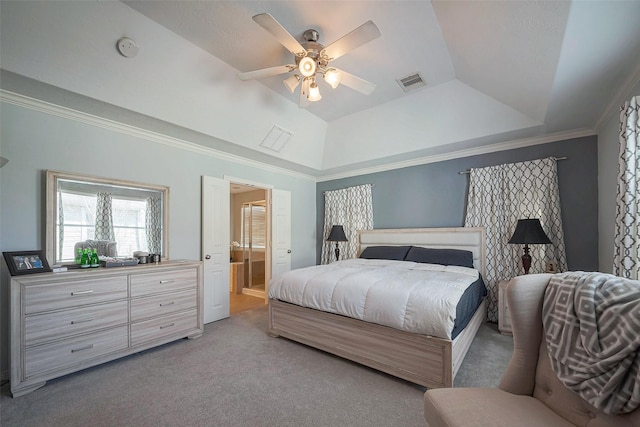 carpeted bedroom featuring a tray ceiling, crown molding, visible vents, connected bathroom, and ceiling fan