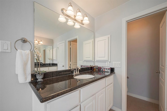 bathroom with tile patterned flooring, toilet, vanity, and baseboards