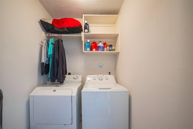 washroom with laundry area, a textured ceiling, and independent washer and dryer