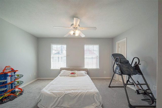 bedroom featuring carpet, baseboards, and a textured ceiling