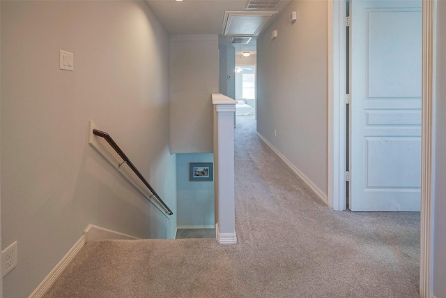 hall with carpet floors, attic access, visible vents, and an upstairs landing