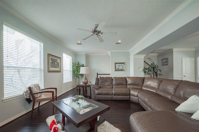 living area with baseboards, wood finished floors, decorative columns, and crown molding