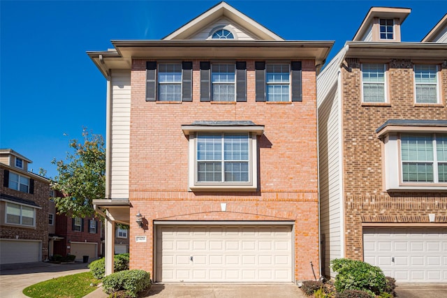 view of front facade featuring concrete driveway, brick siding, and an attached garage