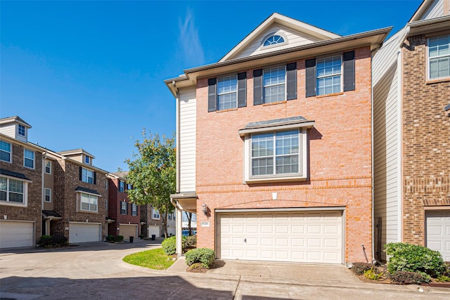 multi unit property featuring a garage, concrete driveway, and brick siding