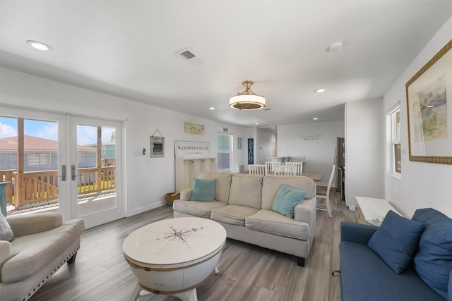 living area featuring recessed lighting, visible vents, baseboards, and wood finished floors