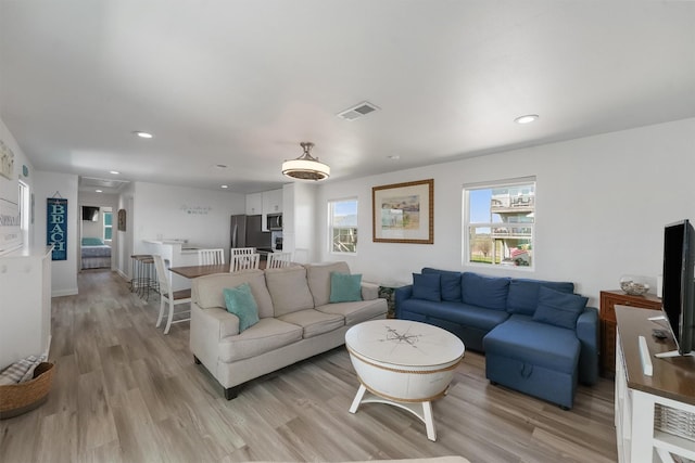 living room with light wood-style floors, recessed lighting, and visible vents