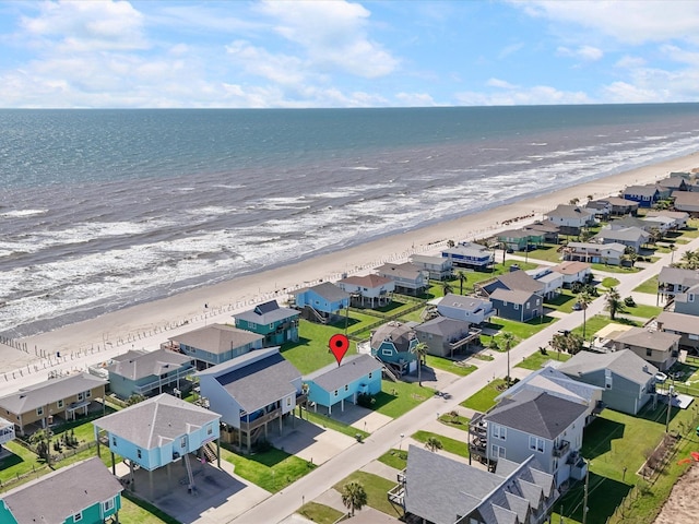 drone / aerial view with a residential view, a water view, and a beach view