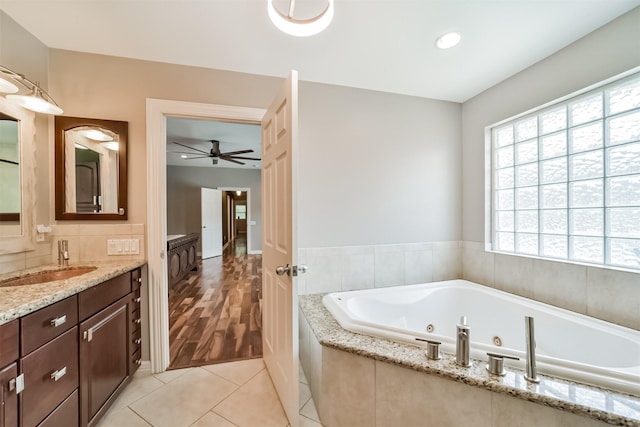 bathroom with vanity, a whirlpool tub, ceiling fan, tile patterned floors, and backsplash