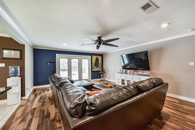 living room featuring wood finished floors, baseboards, visible vents, ornamental molding, and french doors