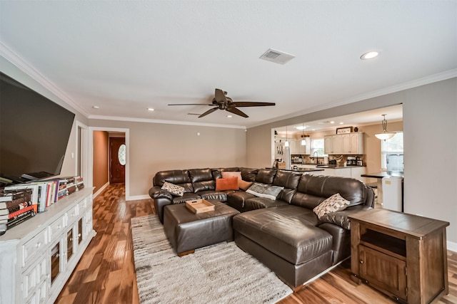 living room featuring recessed lighting, baseboards, light wood-style floors, and ornamental molding