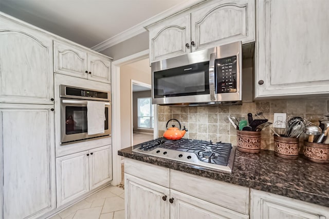 kitchen featuring decorative backsplash, stainless steel appliances, crown molding, and dark stone counters