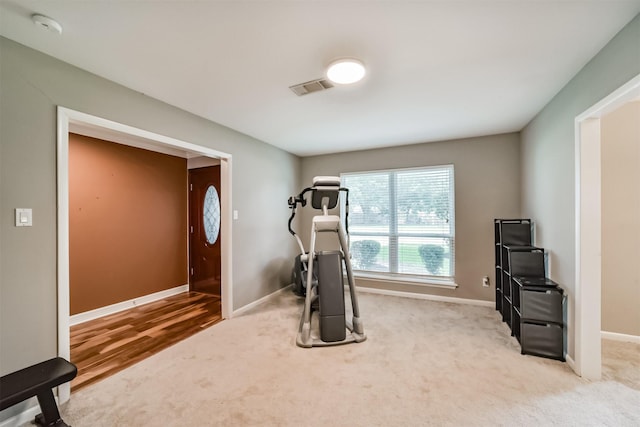 exercise room with visible vents, carpet, and baseboards