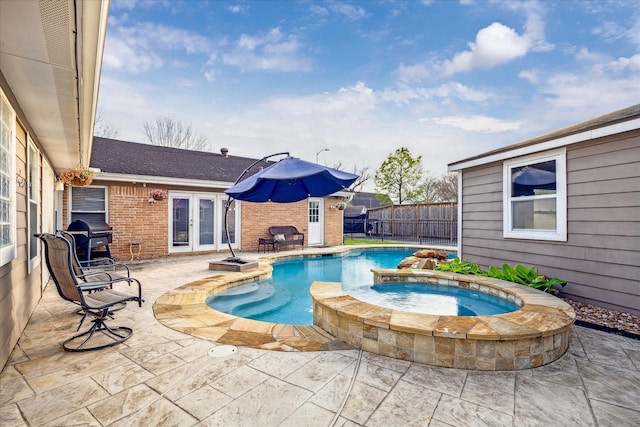 view of swimming pool with grilling area, a pool with connected hot tub, fence, french doors, and a patio