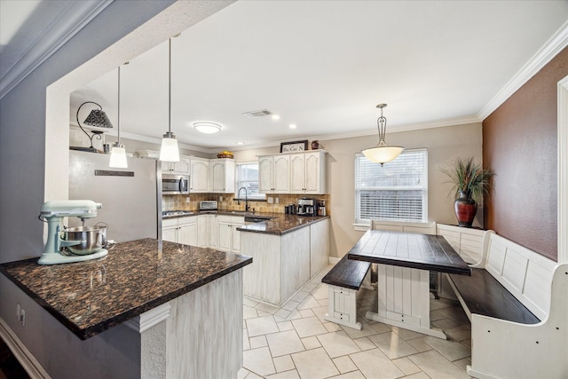 kitchen with visible vents, breakfast area, ornamental molding, a peninsula, and stainless steel appliances