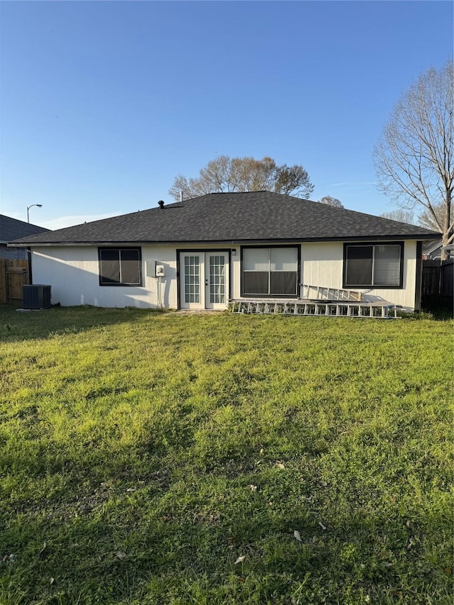 view of front of house with a front yard, fence, and central air condition unit