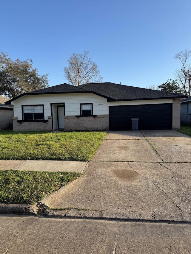 view of front of property featuring a garage, brick siding, a shingled roof, driveway, and a front yard