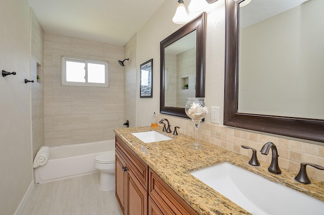 full bathroom featuring a sink, tasteful backsplash, washtub / shower combination, and toilet