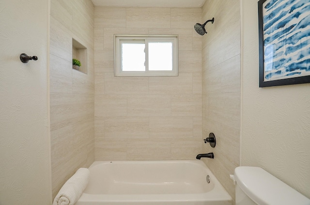 full bathroom with toilet,  shower combination, and a textured wall