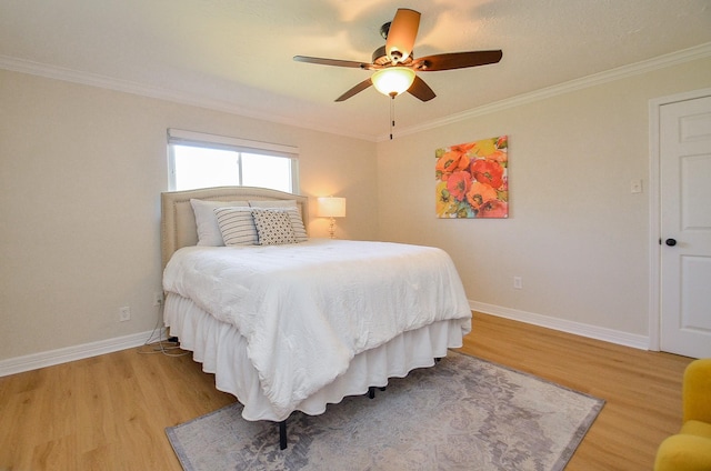 bedroom with baseboards, light wood-style flooring, a ceiling fan, and ornamental molding