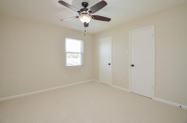 unfurnished bedroom with baseboards, light carpet, and a ceiling fan