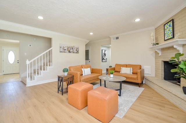 living area featuring light wood finished floors, visible vents, crown molding, stairway, and a textured ceiling