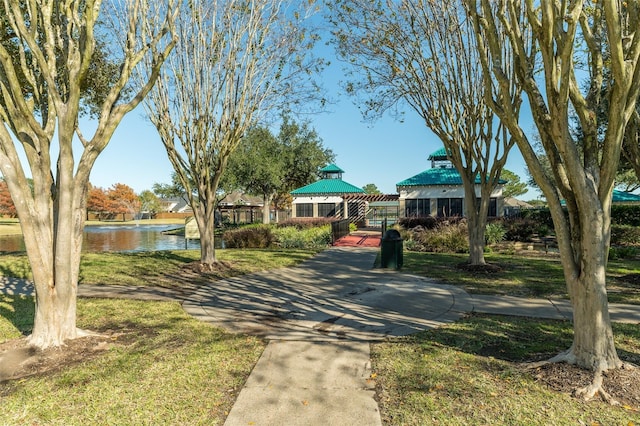 surrounding community featuring a lawn and a water view