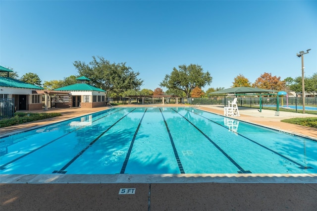 pool with a patio and fence