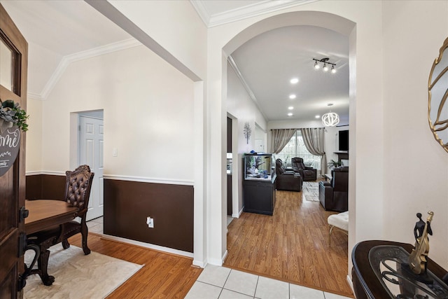 home office with wood finished floors, arched walkways, crown molding, baseboards, and vaulted ceiling