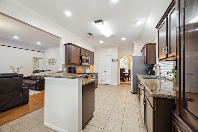 kitchen with visible vents, a sink, stainless steel microwave, open floor plan, and light tile patterned floors