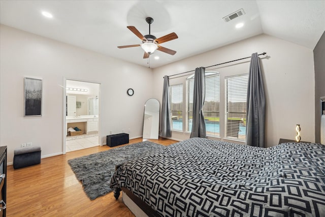 bedroom featuring wood finished floors, visible vents, lofted ceiling, recessed lighting, and ensuite bathroom