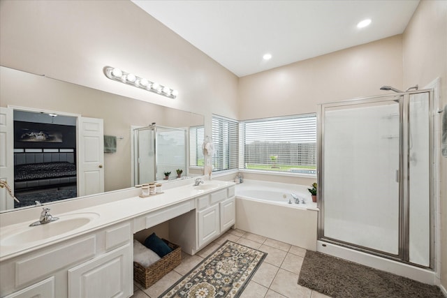 ensuite bathroom featuring tile patterned flooring, a garden tub, a stall shower, and a sink