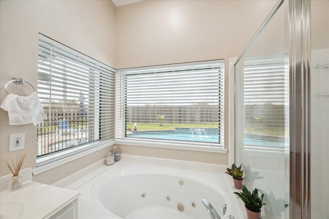 bathroom with a tub with jets and vanity