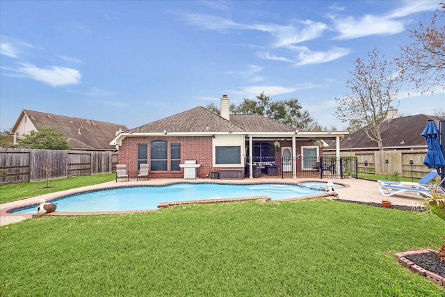 view of swimming pool with a patio, a lawn, area for grilling, and a fenced backyard